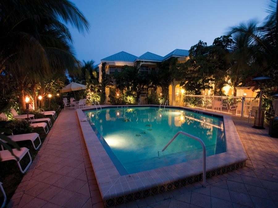 The Caribbean Court Boutique Hotel pool with lounge chairs and tropical landscaping