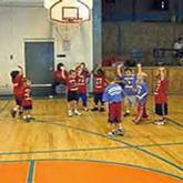Young kids playing basketball in gymnasium
