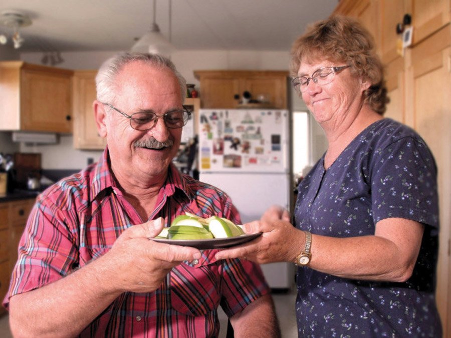 Woman giving gentleman a plate of food