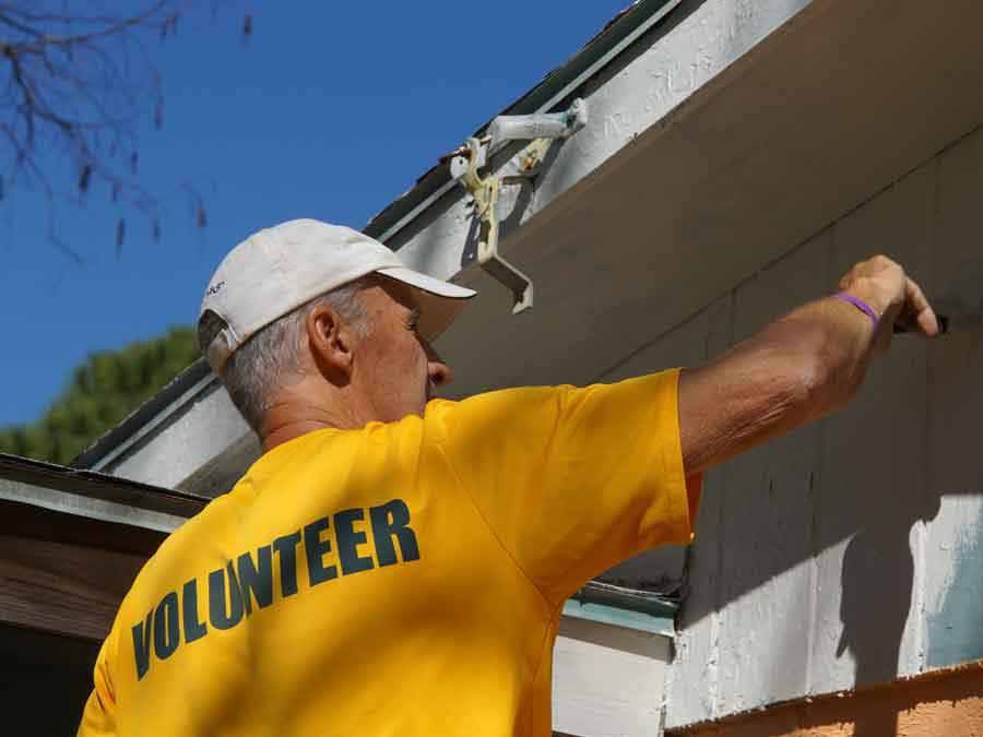 Volunteer painting exterior wall