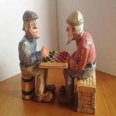 Wood carving of two men playing checkers