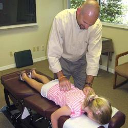 Dr. Parris adjusting young girl's back