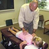 Dr. Parris adjusting young girl's back