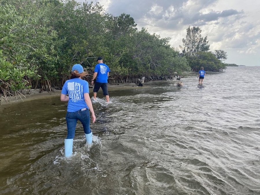 volunteers searching rivers edge for trash