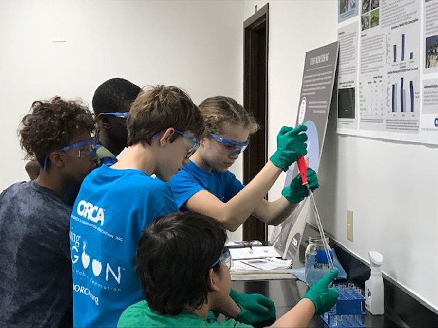 Five students with protective glasses around lab testing equipment at Center for Citizen Science in Vero Beach