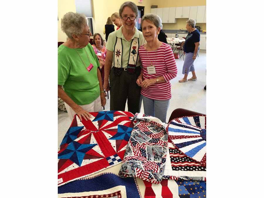 three women admiring patriotic items mad at guild