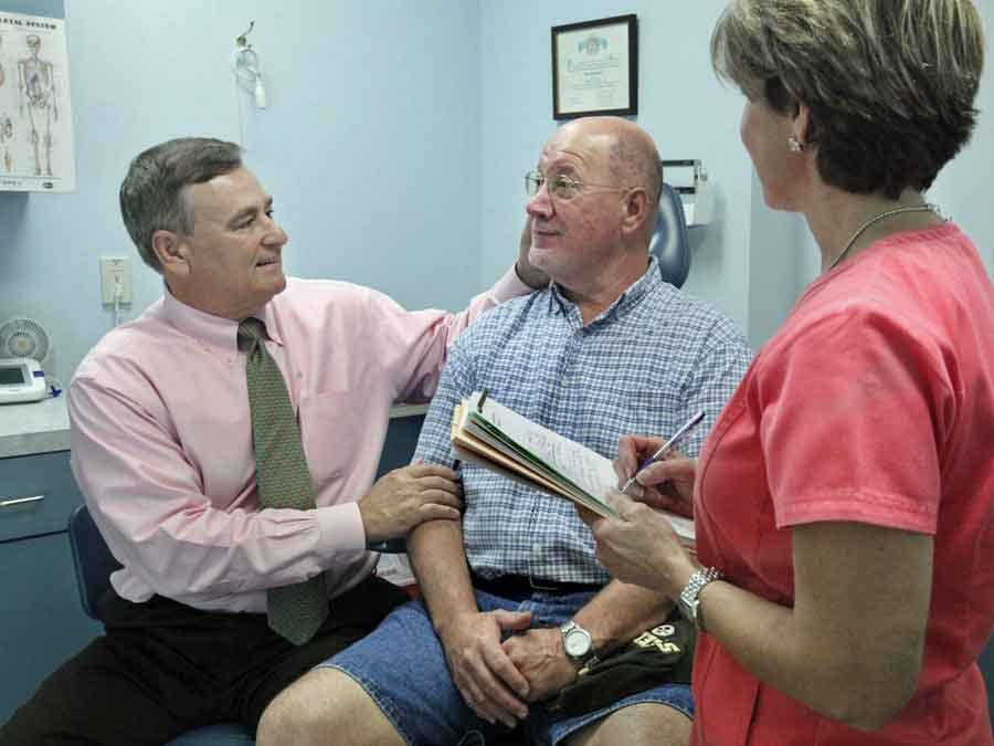 Ralph Rosato MD examining patient with nurse looking on