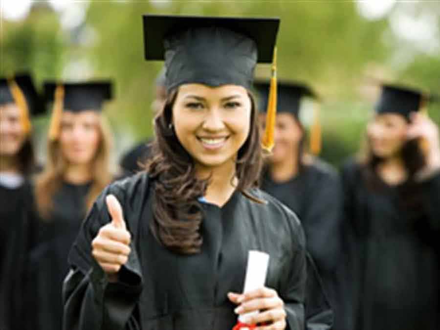 girl in graduation gown giving thumbs up
