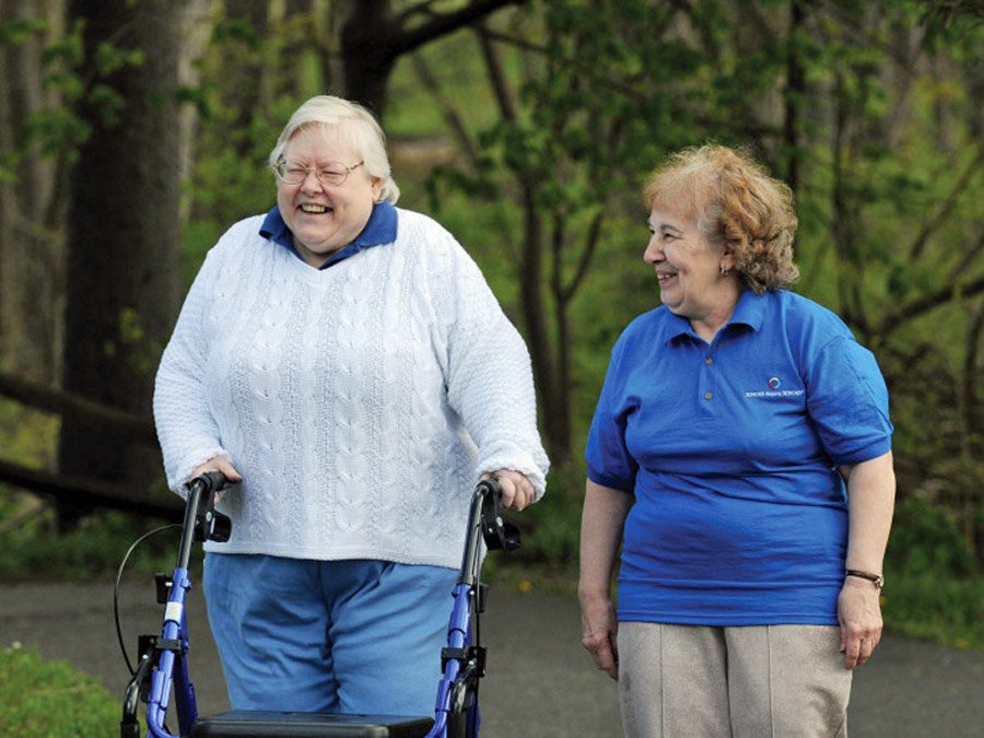two women taking a walk. One has a walker
