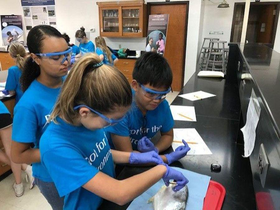 Three students with protective glasses performing lab work at the Center for Citizen Science in Vero Beach